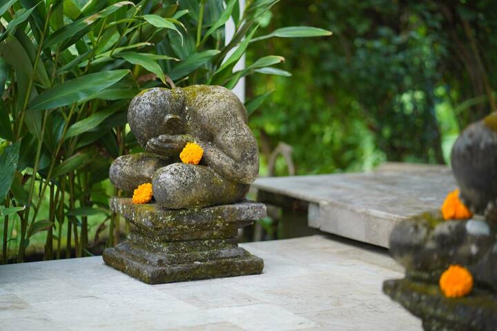 A stone figure with marigold offerings